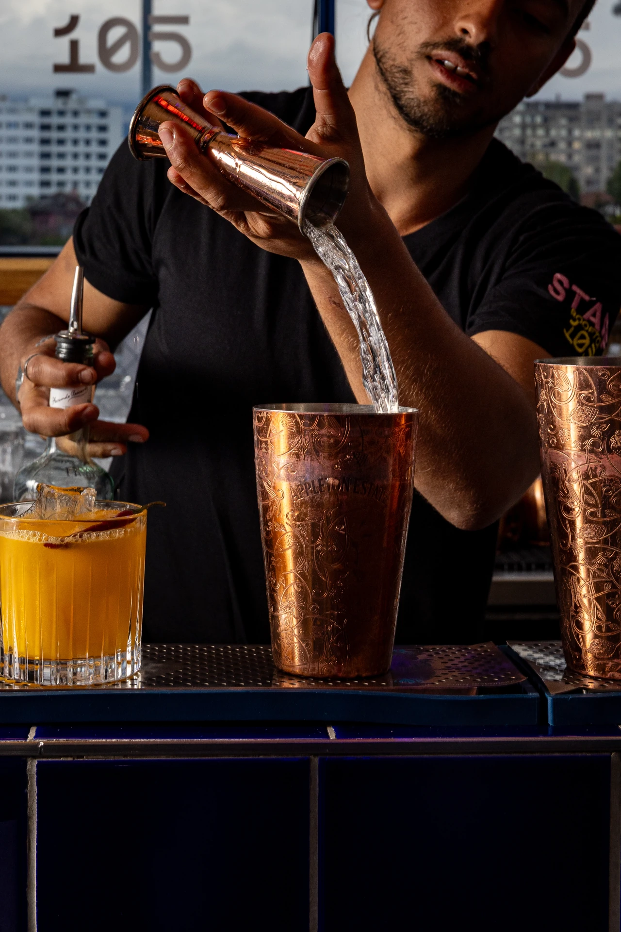 Bartender versant un trait d'alcool dans un shaker cuivre Appleton Estate
