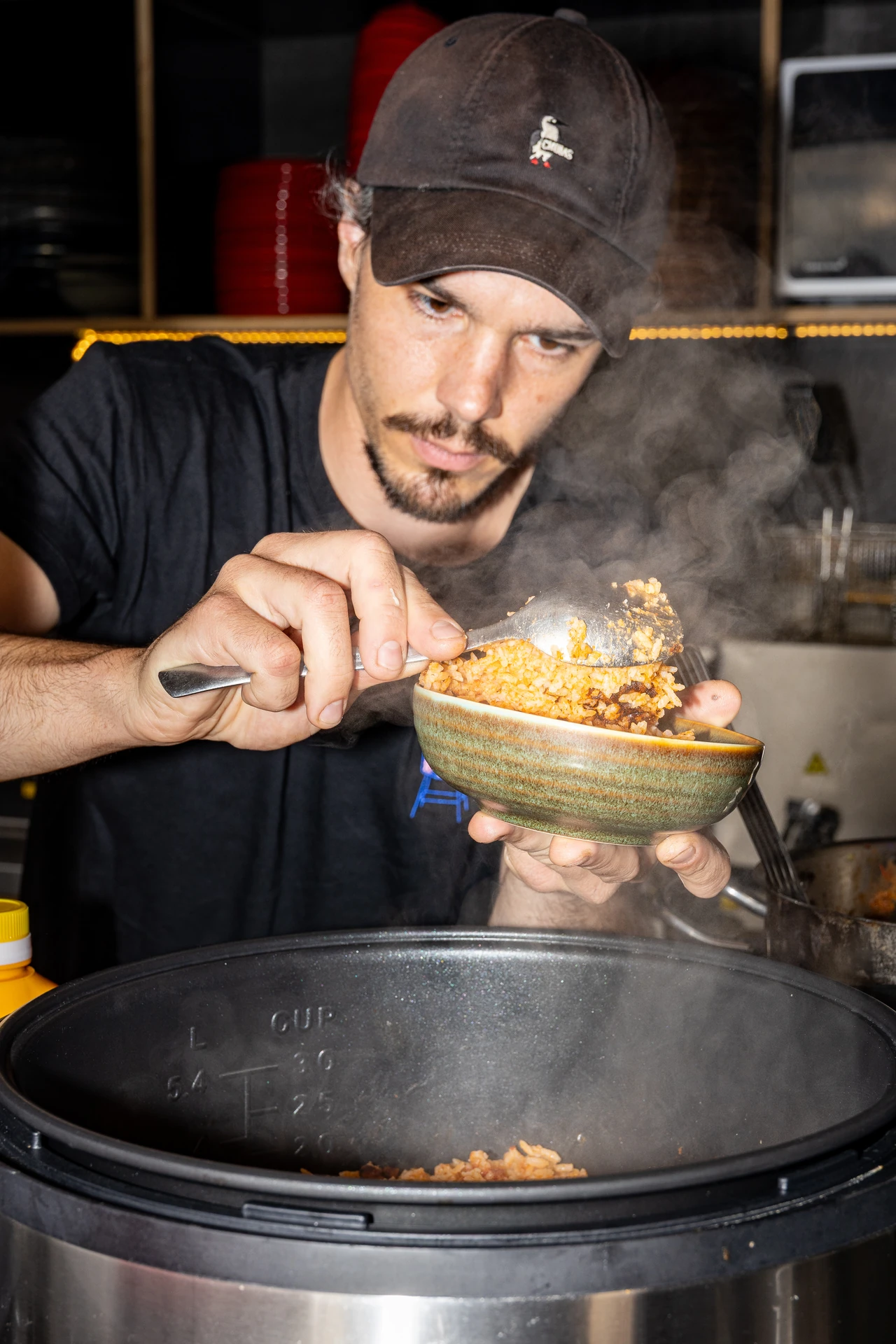 Chef du Rooftop 105 servant le riz mexicain à la vapeur en cuisine