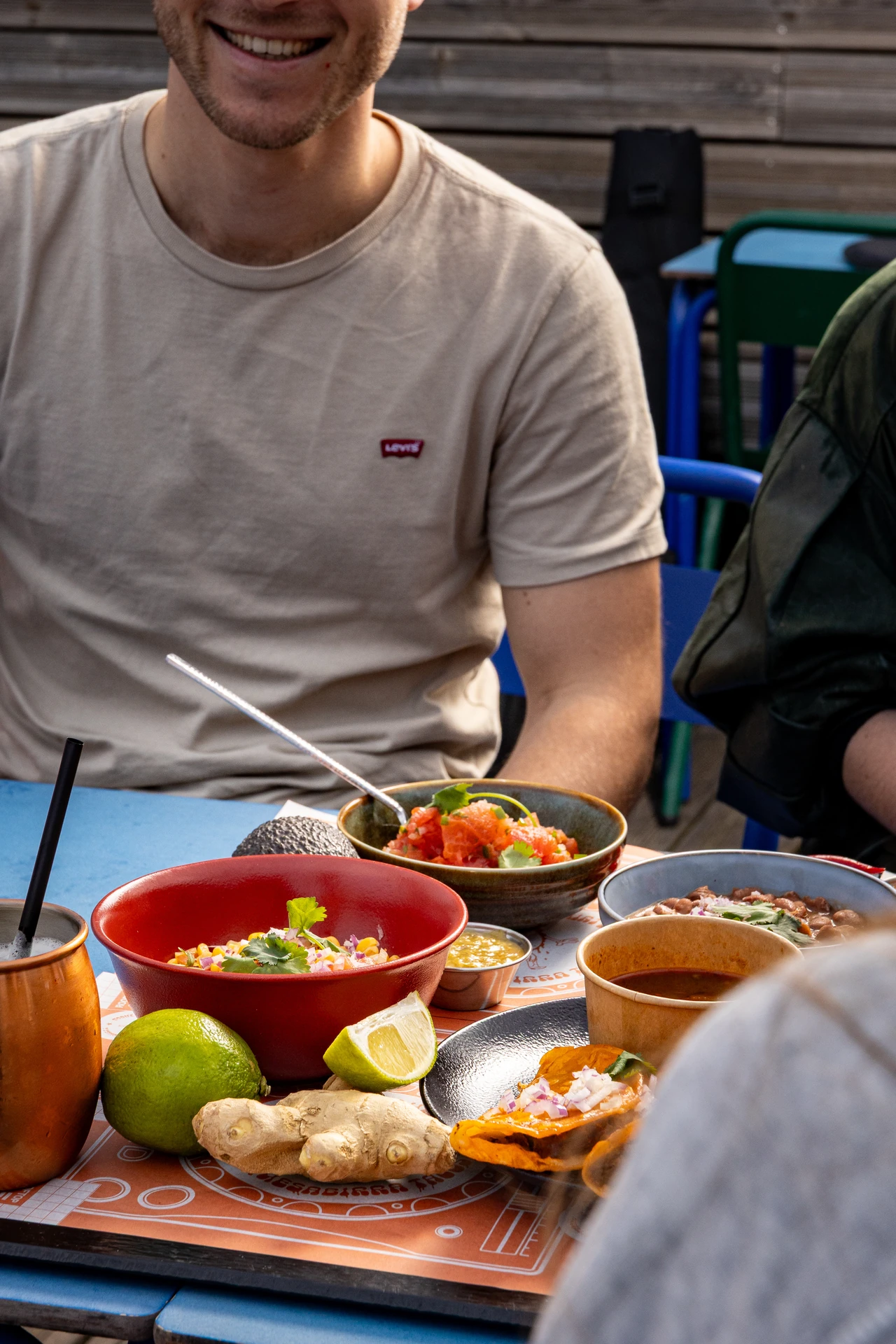 Client souriant face à un feast mexicain complet, mug Moose Mule en cuivre