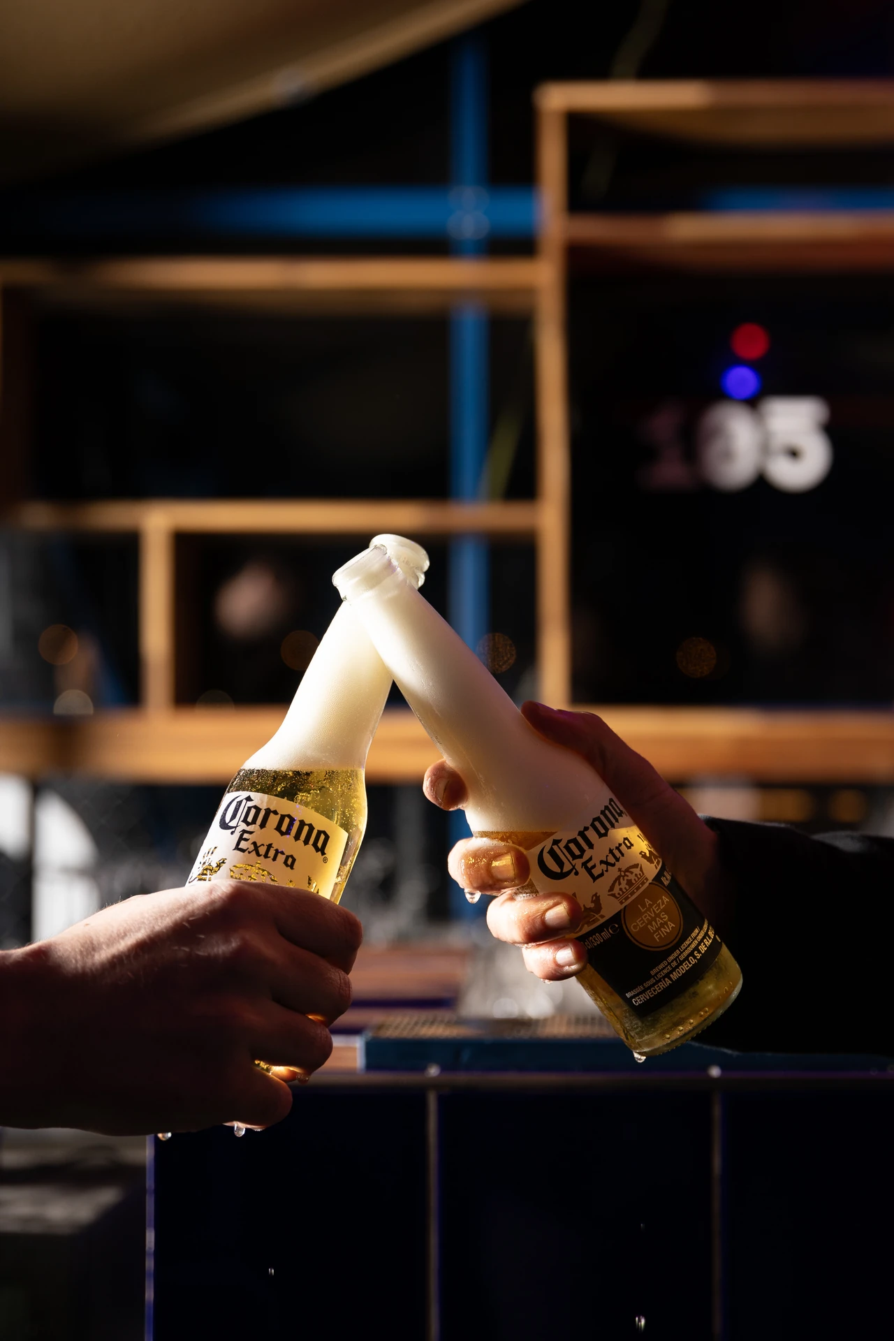Deux Coronas qui trinquent devant le mur 105 du bar