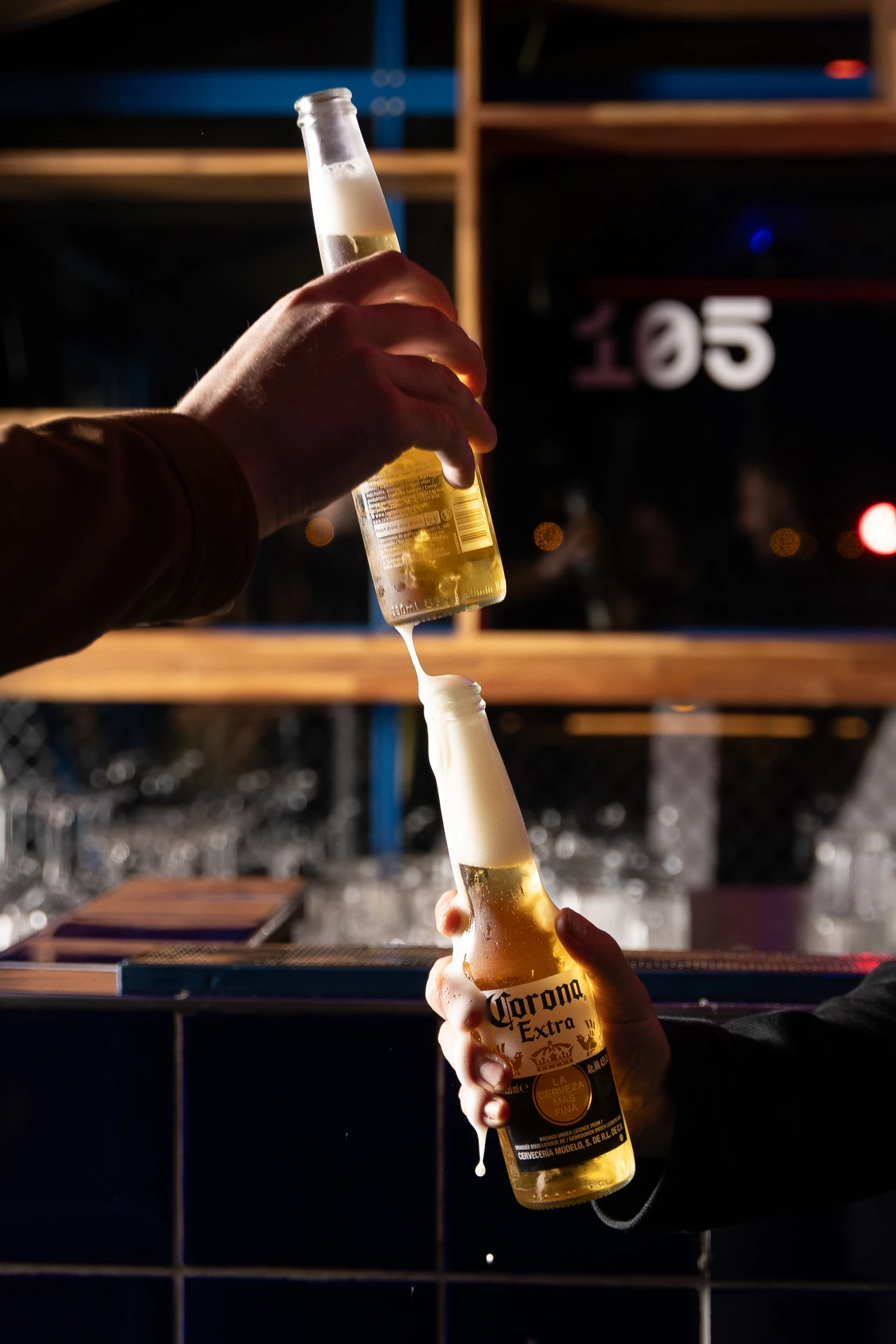 Bartender versant une Corona derrière le bar 105 en pleine nuit