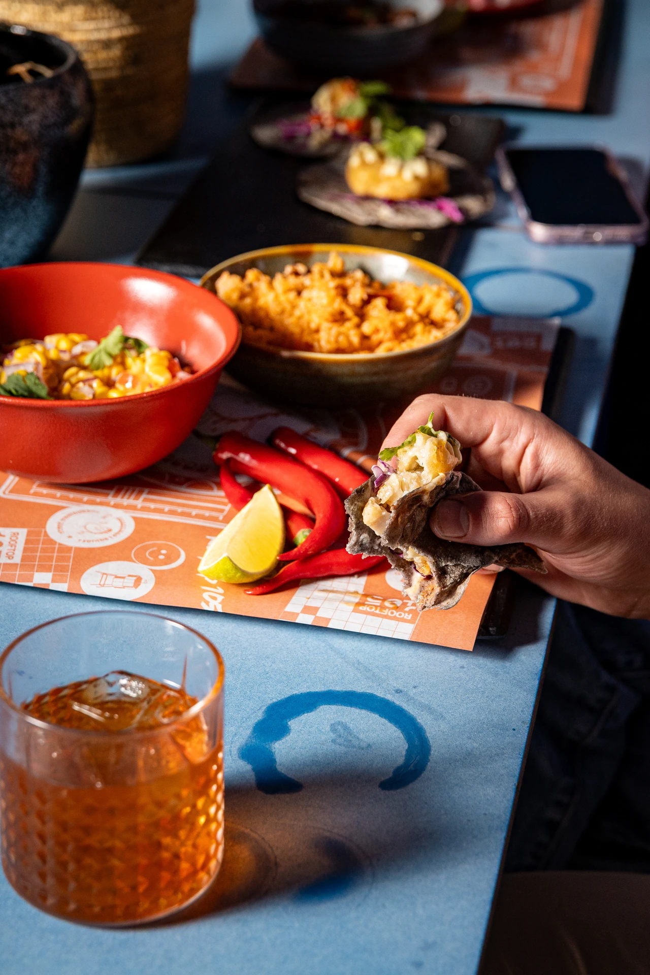 Tacos partagés sur set de table orange Rooftop 105